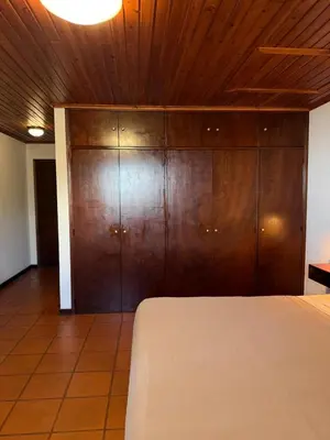 a bedroom with a bed and wooden cabinets at Habitación con Cocina en la Montaña in Funchal