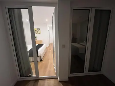a bedroom with a bed and a sliding glass door at Luxury Apartament NEXT to SAVOY in Funchal