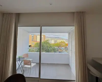 a room with a balcony with a view of a building at Luxury Apartament NEXT to SAVOY in Funchal