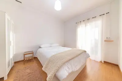 a white bedroom with a bed and a window at Abrigo dos Prazeres Guesthouse by Mth in Prazeres