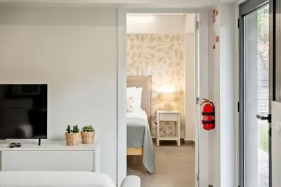 a bedroom with a bed and a tv in a room at Central Apartment Steps From Beach in Ponta do Sol
