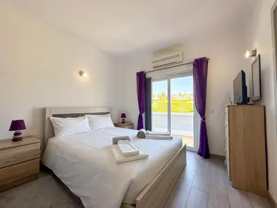 a bedroom with a bed and a window with purple curtains at Casa Bella - a charming holiday house in Luz in Luz