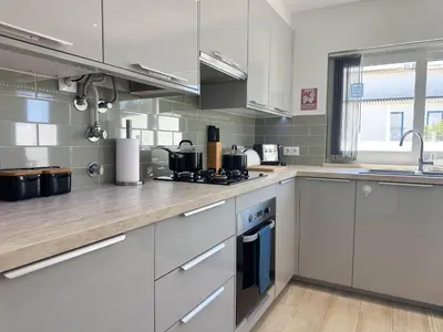 a kitchen with stainless steel appliances and white cabinets at Casa Bella - a charming holiday house in Luz in Luz