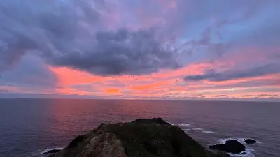 a sunset over the ocean with a rock in the water at Ocaso - Aljezur sea view stunning sunsets Arrifana in Aljezur