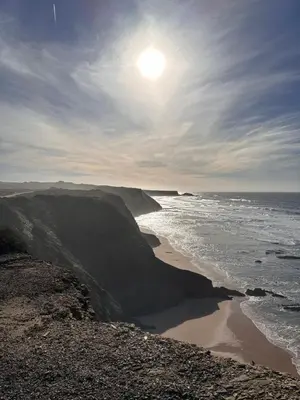 a view of the ocean and a beach with the sun at Ocaso - Aljezur sea view stunning sunsets Arrifana in Aljezur