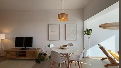 a living room with a table and a tv at Ocaso - Aljezur sea view stunning sunsets Arrifana in Aljezur