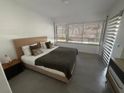 a bedroom with a bed and a large window at Infante Home I in Funchal