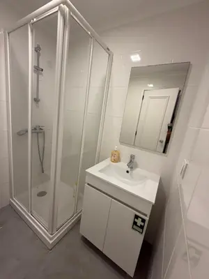 a white bathroom with a shower and a sink at Infante Home I in Funchal
