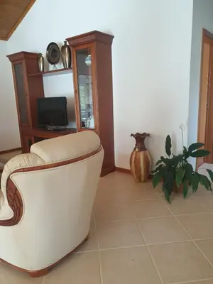 a living room with a chair and a tv at Farol Golfe in Ponta do Pargo
