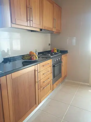 a kitchen with wooden cabinets and a plate of fruit at Farol Golfe in Ponta do Pargo
