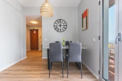 a dining room with a table and chairs and a clock at Lido Edge View - Ocean View by Atlantic View in Funchal
