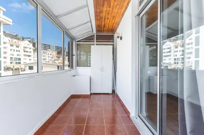 an empty balcony with glass doors and a tile floor at Lido Edge View - Ocean View by Atlantic View in Funchal