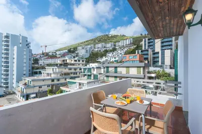 a table on a balcony with a view of a city at Lido Edge View - Ocean View by Atlantic View in Funchal