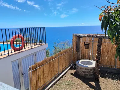 a table on a deck with a view of the ocean at Villa Falésia Atlântica I in Ribeira Brava