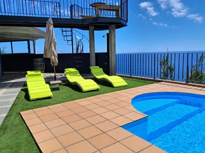 a living room with a couch and a flat screen tv at Villa Falésia Atlântica I in Ribeira Brava