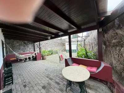 a patio with a couch and a table and chairs at Casa da Torre in Porto Moniz