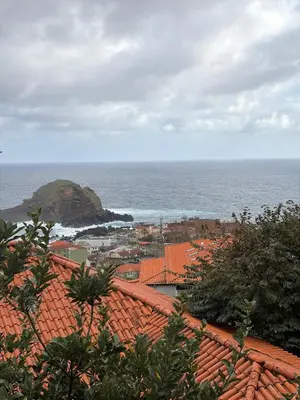 a view of the ocean from the roofs of a town at Casa da Torre in Porto Moniz