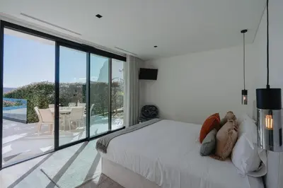 a bedroom with a bed and a view of a patio at Villa Guindaste II Luxury with Pool & Sea View in Santana