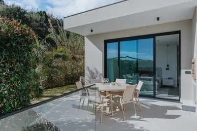 a dining room with a table and chairs on a patio at Villa Guindaste II Luxury with Pool & Sea View in Santana