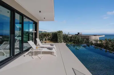 a house with a swimming pool and two white chairs at Villa Guindaste II Luxury with Pool & Sea View in Santana