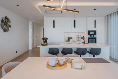 a kitchen with white cabinets and a table and chairs at Villa Guindaste II Luxury with Pool & Sea View in Santana