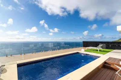a swimming pool with a view of the ocean at GuestReady - The Ocean El Cid in Fajã da Ovelha