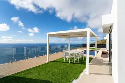 a white gazebo on the deck of a house at GuestReady - The Ocean El Cid in Fajã da Ovelha