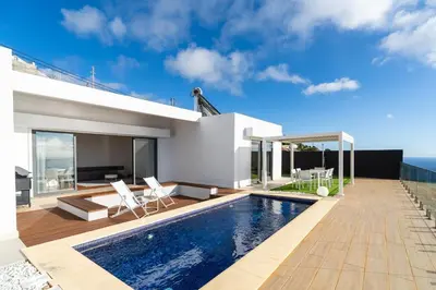 a swimming pool in the backyard of a house at GuestReady - The Ocean El Cid in Fajã da Ovelha