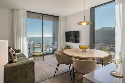 a living room with a table and chairs and a large window at Calheta Hills IV Apartment with Sea View in Calheta