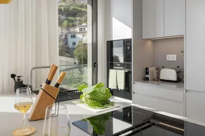 a kitchen with a counter with a wine glass at Calheta Hills IV Apartment with Sea View in Calheta