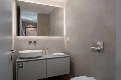a white bathroom with a sink and a mirror at Calheta Hills IV Apartment with Sea View in Calheta