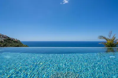 a swimming pool with the ocean in the background at Calheta Hills IV Apartment with Sea View in Calheta