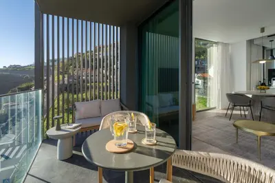 a living room with a table and chairs and a balcony at Calheta Hills IV Apartment with Sea View in Calheta