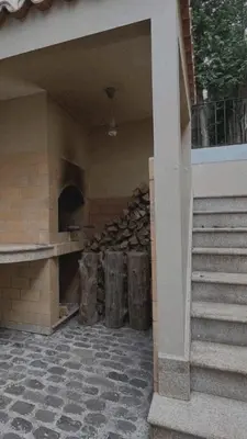 a building with a pile of fire wood next to stairs at House Pilar close to Funchal in Funchal