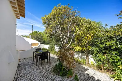 a patio with a table and a bench next to a wall at Casa 54 in Valverde