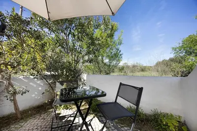 a patio with a table and an umbrella at Estúdio Agostinho in Luz
