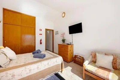 a kitchen with a small table and a microwave on top of a refrigerator at Estúdio Agostinho in Luz