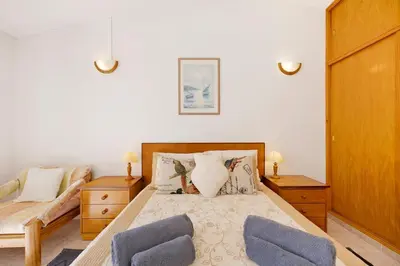 a bedroom with two beds and a flat screen tv at Estúdio Agostinho in Luz