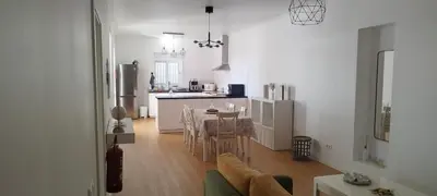 a kitchen and living room with a table and chairs at Moradia Girassol Porto Santo in Porto Santo
