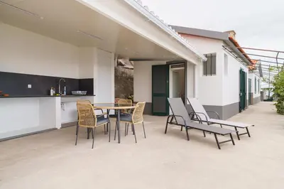 a patio with a table and chairs and a kitchen at GuestReady - Funchal Hideaway with BBQ in Funchal