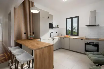 a kitchen with a wooden table and white cabinets at Casa Maria Bela 2-Bedroom with Terrace in Calheta