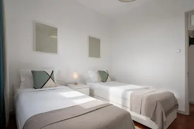 two beds in a room with white walls at Casa Maria Bela 2-Bedroom with Terrace in Calheta