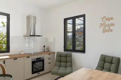 a kitchen with two chairs and a table in a kitchen at Casa Maria Bela 2-Bedroom with Terrace in Calheta