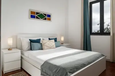 a white bedroom with a large bed and a window at Casa Maria Bela 2-Bedroom with Terrace in Calheta