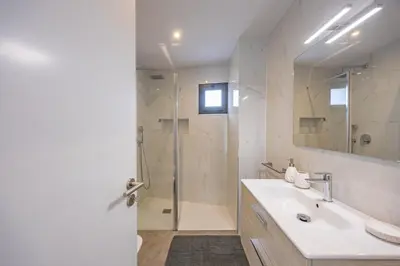 a white bathroom with a sink and a shower at Aurea Maris By YOUR KEY MADEIRA in Câmara de Lobos