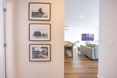 a living room with framed pictures on a wall at Aurea Maris By YOUR KEY MADEIRA in Câmara de Lobos