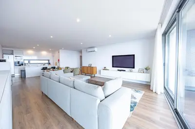 a living room with a couch and a tv at Aurea Maris By YOUR KEY MADEIRA in Câmara de Lobos