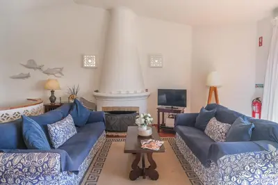 a living room with blue couches and a tv at Casa da Areia, Three Bedroom Villa by the Beach in Luz
