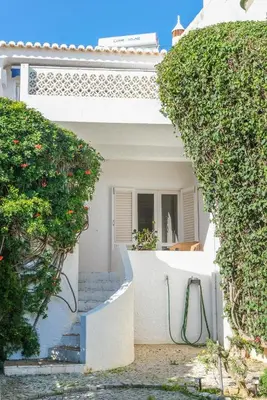 a white house with a staircase and some bushes at Casa da Areia, Three Bedroom Villa by the Beach in Luz