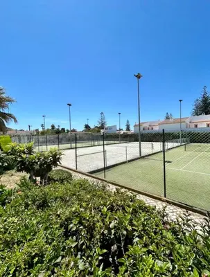 a tennis court with a net on a tennis court at Casa da Areia, Three Bedroom Villa by the Beach in Luz